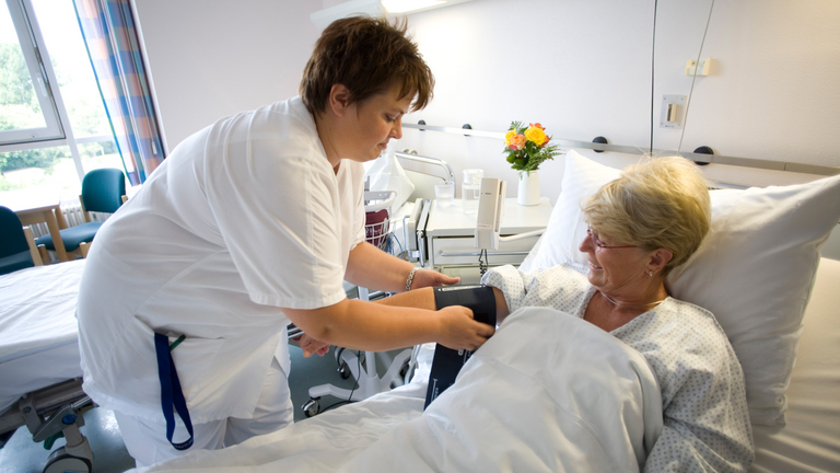 Pflegefachfrau misst Blutdruck bei Patientin - Immanuel Herzzentrum Brandenburg in Bernau bei Berlin - während des Aufenthalts