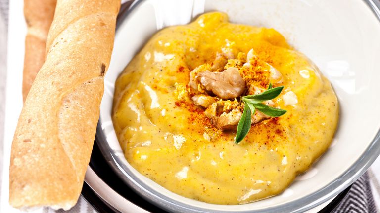 Zubereiteter Pastinaken-Apfel-Aufstrich mit Kurkuma und Zimt in einer Schüssel und dazu Baguette