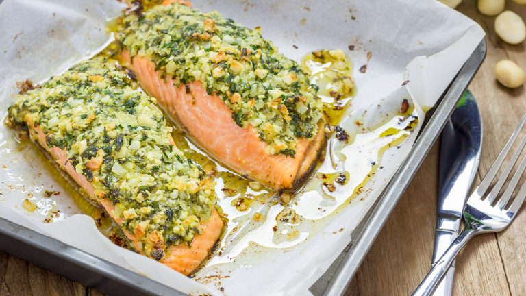 Lachsfilet mit Kartoffel-Pesto-Kruste frisch aus dem Ofen angereicht auf dem Backblech 